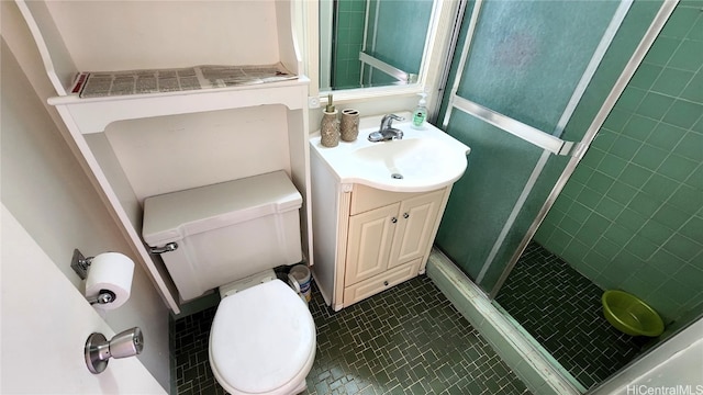 bathroom with a stall shower, vanity, toilet, and tile patterned floors