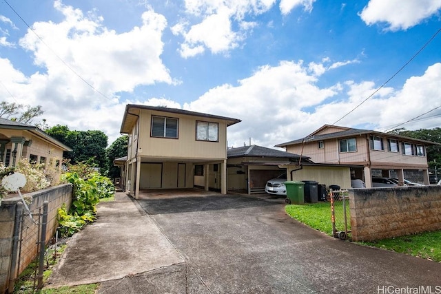 view of front of property featuring driveway and fence