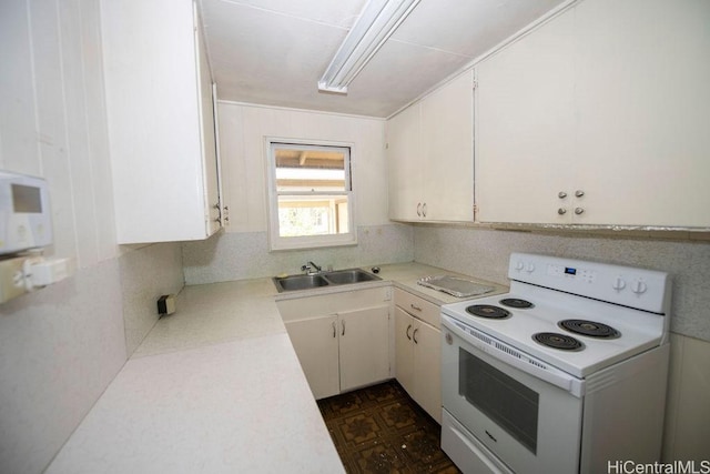 kitchen with light countertops, white appliances, a sink, and white cabinetry