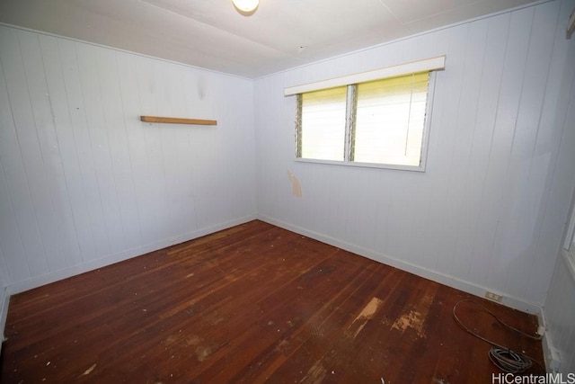 empty room with hardwood / wood-style floors and baseboards