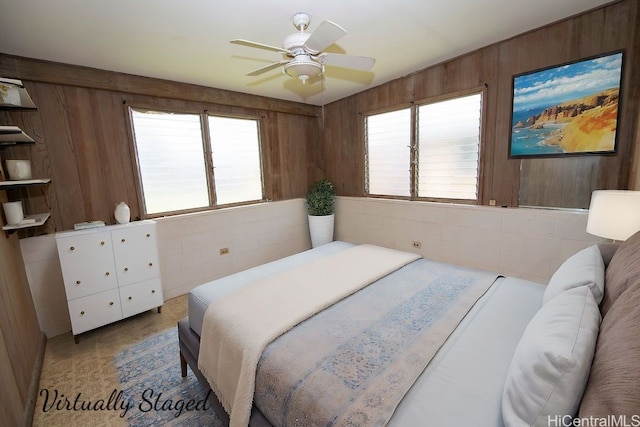 bedroom with wooden walls and a ceiling fan