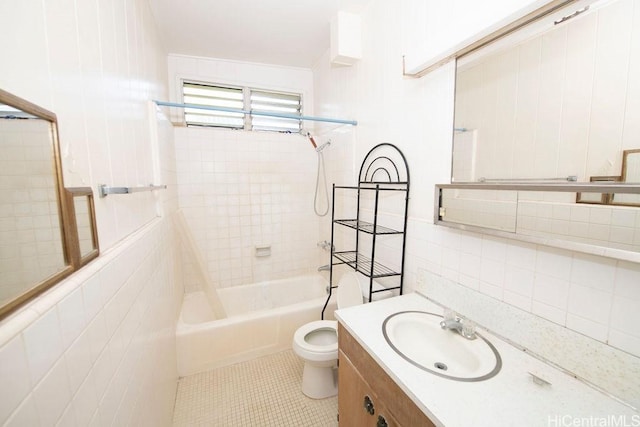 bathroom with shower / washtub combination, tile walls, toilet, vanity, and tile patterned floors