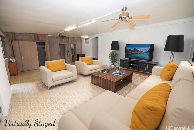 living room featuring a ceiling fan and wooden walls