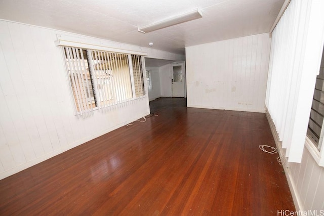 unfurnished room with baseboards and wood finished floors