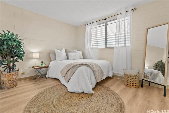 bedroom featuring a textured ceiling and wood finished floors