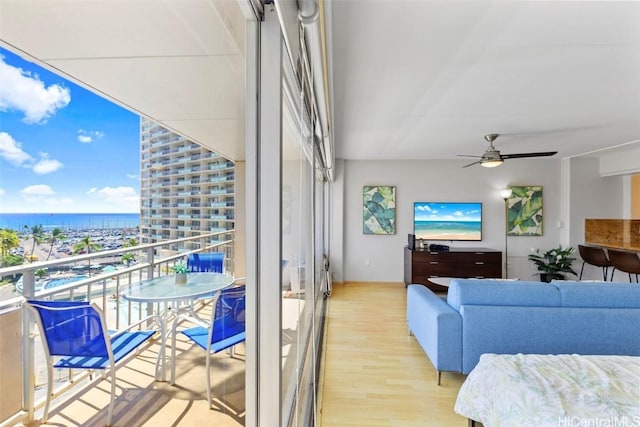 balcony featuring a ceiling fan, a water view, and outdoor lounge area