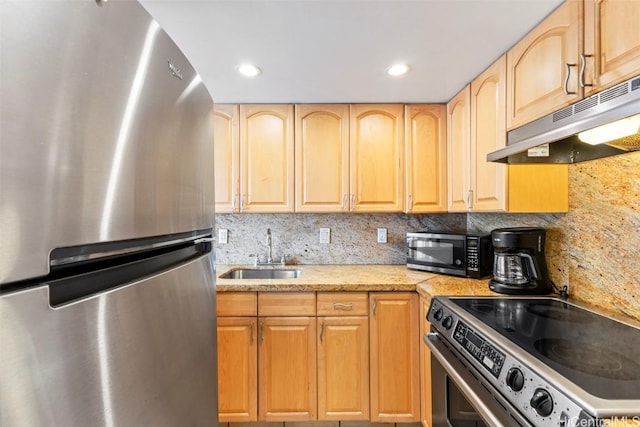 kitchen with decorative backsplash, stainless steel appliances, under cabinet range hood, light brown cabinets, and a sink