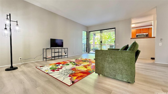 living area with light wood-style floors and baseboards