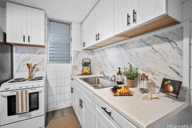 kitchen with white range with electric cooktop, light countertops, white cabinets, a sink, and a textured ceiling