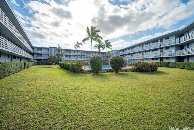 view of property's community featuring a yard and a pool