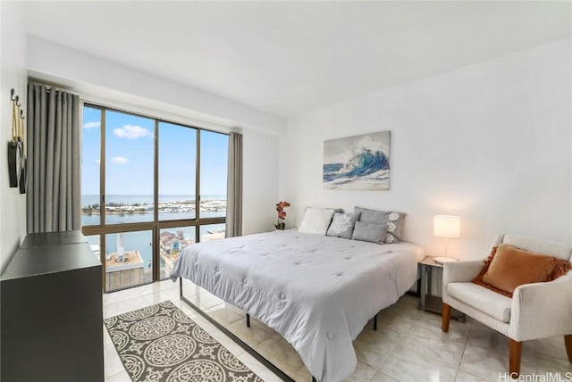 bedroom with a water view and light tile patterned floors