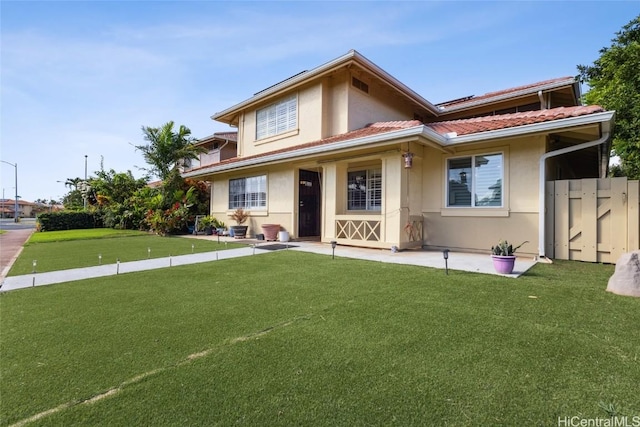 back of house featuring a yard, fence, and stucco siding