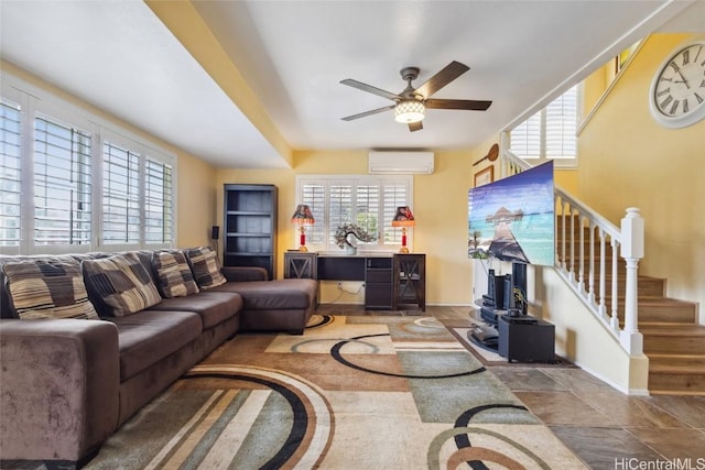 living room featuring baseboards, stairs, a wall mounted AC, and ceiling fan