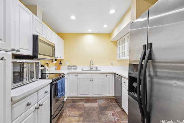 kitchen with a sink, white cabinetry, recessed lighting, appliances with stainless steel finishes, and light countertops