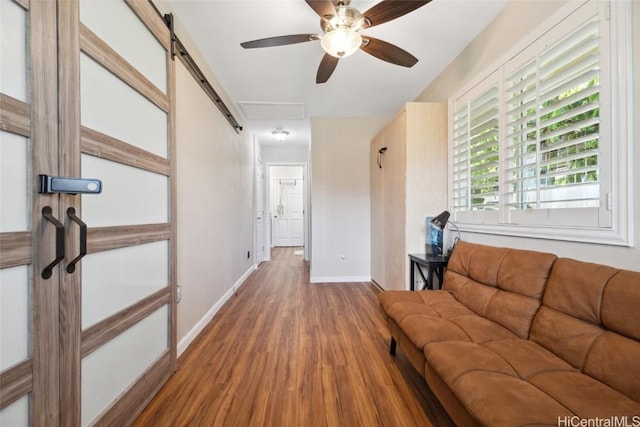 unfurnished living room featuring a ceiling fan, wood finished floors, and baseboards