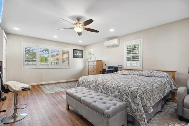 bedroom with recessed lighting, wood finished floors, baseboards, and a wall mounted AC