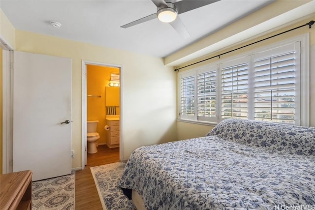 bedroom featuring ceiling fan, wood finished floors, and ensuite bathroom