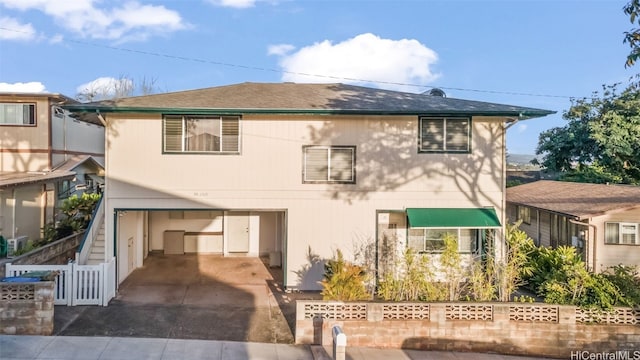 view of front of property with an attached garage, driveway, and fence