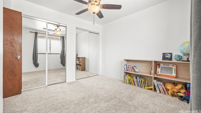 carpeted bedroom with a ceiling fan and two closets