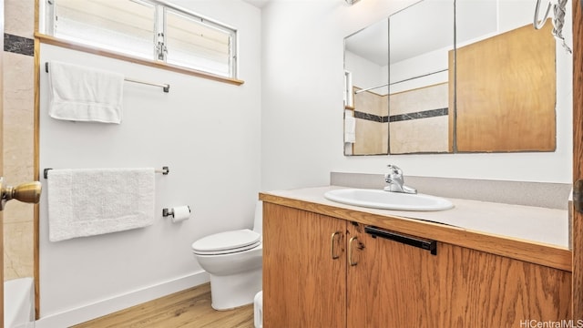 full bathroom featuring toilet, vanity, baseboards, and wood finished floors