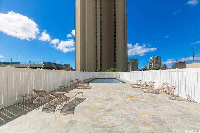 view of patio with fence and a city view