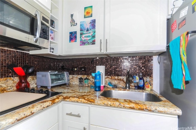 kitchen with appliances with stainless steel finishes, decorative backsplash, a sink, and a toaster