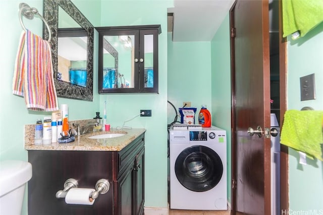 bathroom with toilet, washer / dryer, and vanity