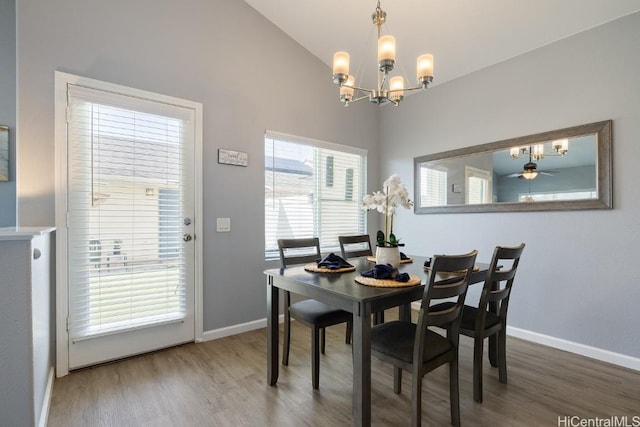 dining room with a notable chandelier, baseboards, vaulted ceiling, and wood finished floors