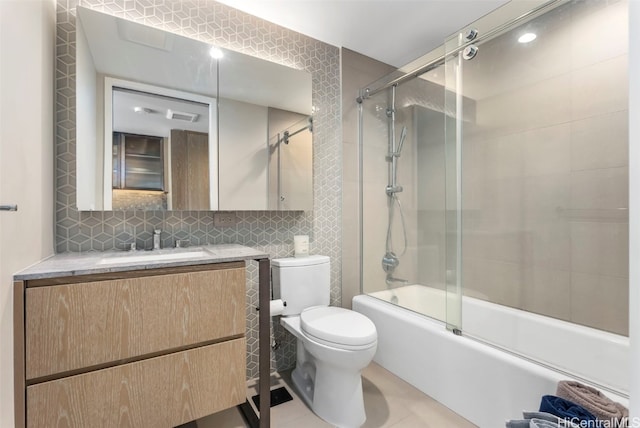 bathroom featuring backsplash, toilet, vanity, shower / bath combination with glass door, and tile walls