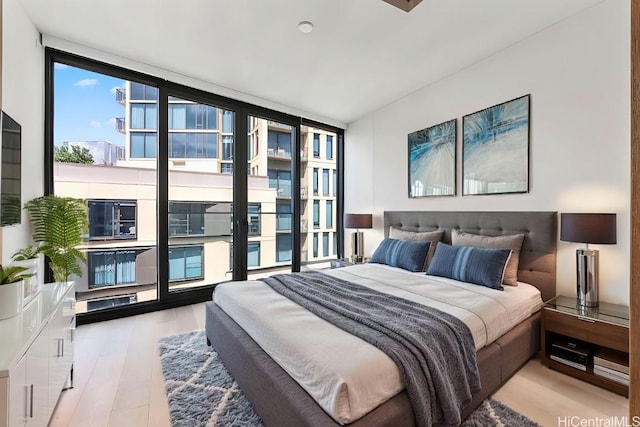 bedroom featuring wood finished floors and expansive windows