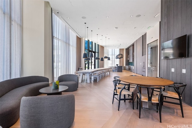 dining area with floor to ceiling windows and light wood-style flooring