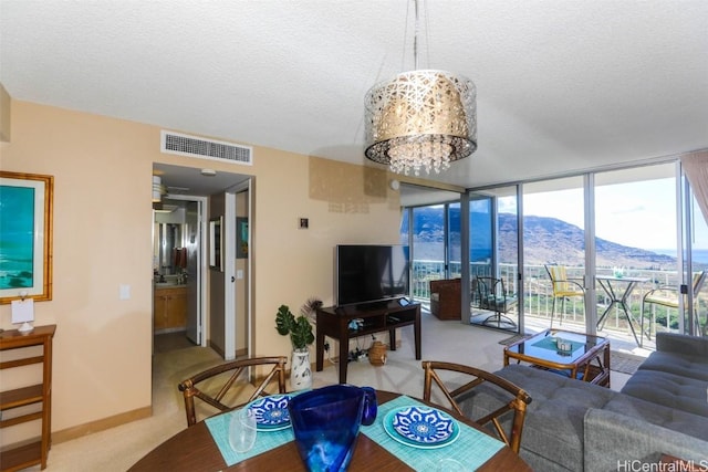 living area featuring carpet floors, expansive windows, visible vents, and a textured ceiling