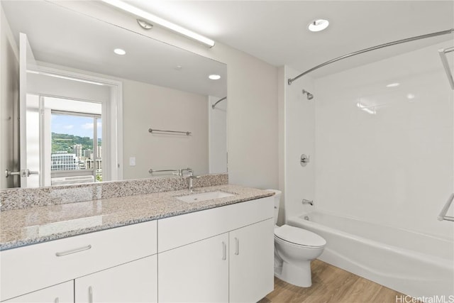 bathroom featuring recessed lighting, shower / bath combination, toilet, vanity, and wood finished floors