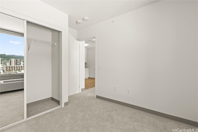 unfurnished bedroom with a closet, baseboards, and carpet flooring