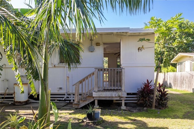 property entrance featuring a yard and fence