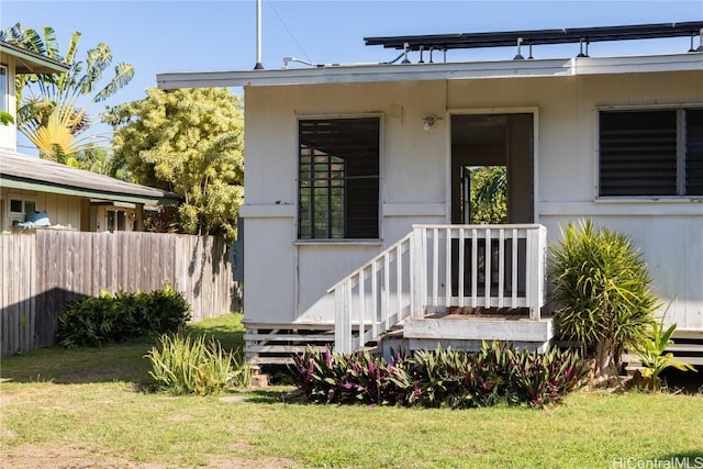 view of front of house with a front lawn and fence