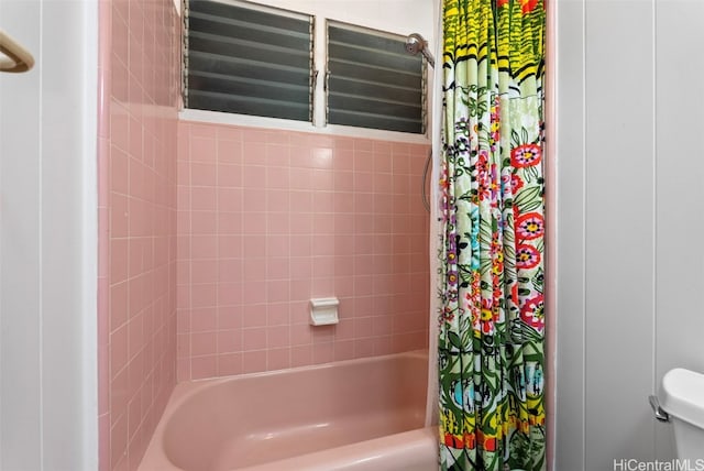 bathroom with shower / bath combination with curtain and toilet