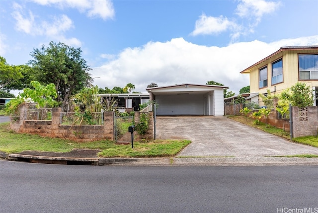 view of front of home with driveway, fence, and a carport