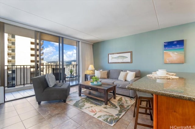 living room featuring a wall of windows and light tile patterned flooring