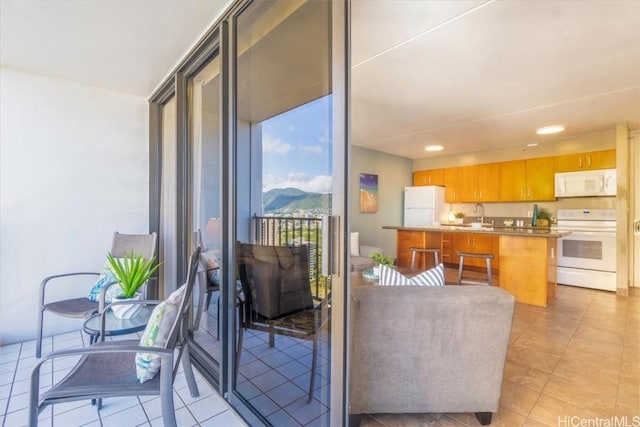 balcony with a mountain view, an outdoor kitchen, and a sink