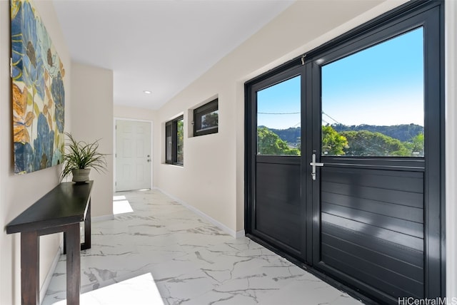 doorway to outside featuring marble finish floor, recessed lighting, and baseboards