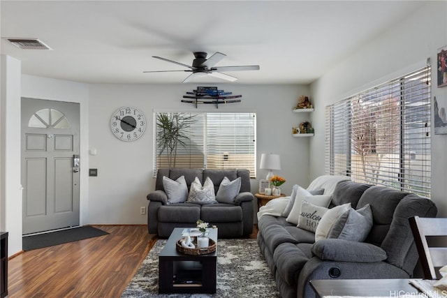 living area featuring dark wood-style floors, visible vents, and a ceiling fan