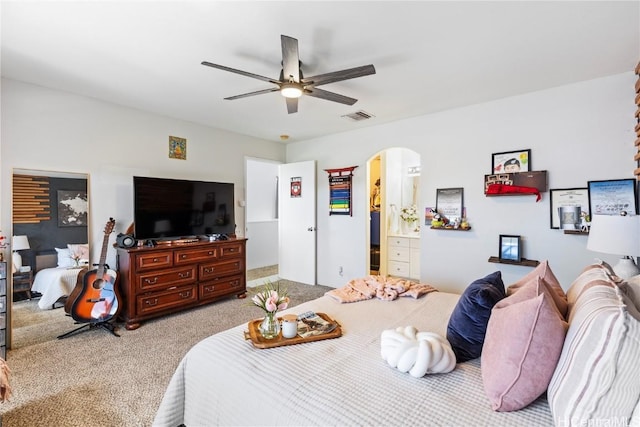 bedroom featuring arched walkways, visible vents, ceiling fan, and carpet flooring