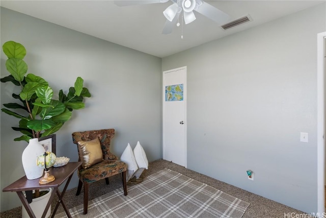 living area featuring a ceiling fan, visible vents, and light carpet