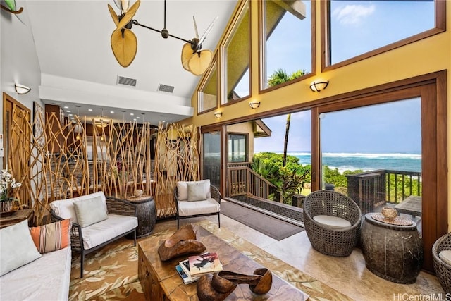 common area with a sunroom, a water view, and visible vents