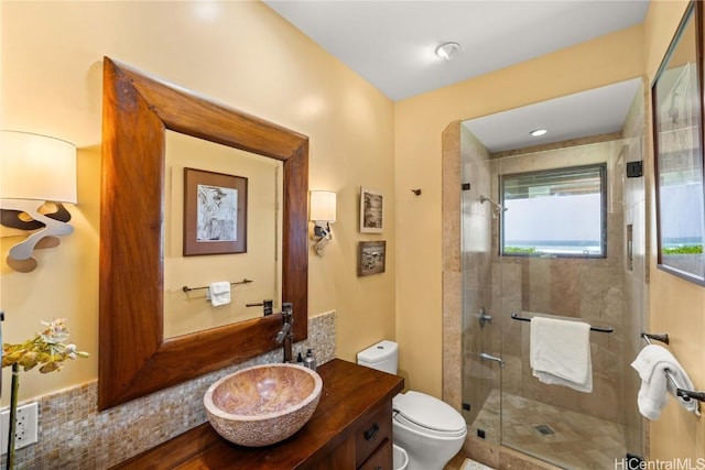 bathroom featuring a stall shower, vanity, and toilet