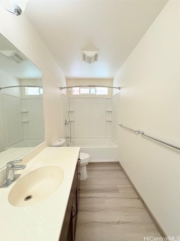 full bathroom with plenty of natural light, toilet, bathing tub / shower combination, and wood finished floors