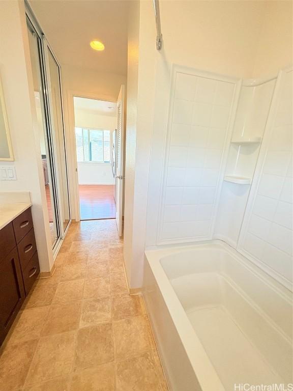 full bathroom with a bathing tub, vanity, and a shower