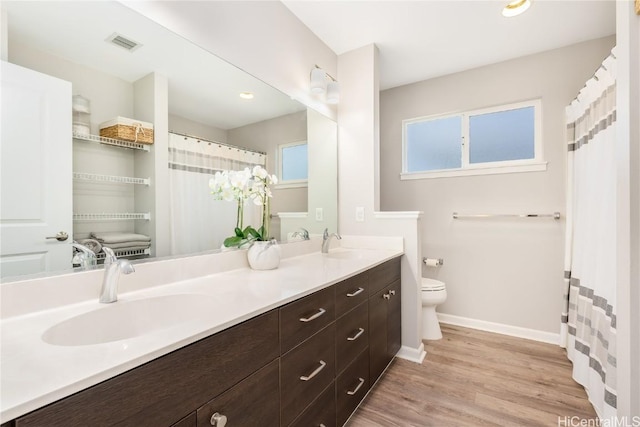 full bath featuring a sink, visible vents, toilet, and wood finished floors
