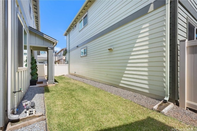 view of side of property with a yard and fence